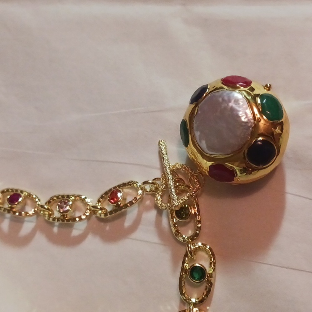 Vibrant Gold and Red Necklace with Intricate Chain and Spherical Pendant